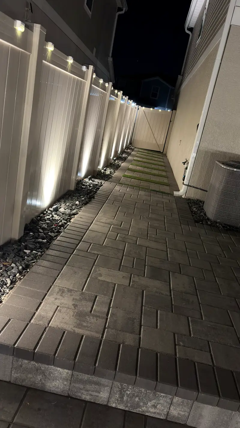 Turf strip and pavers between the house and the fence